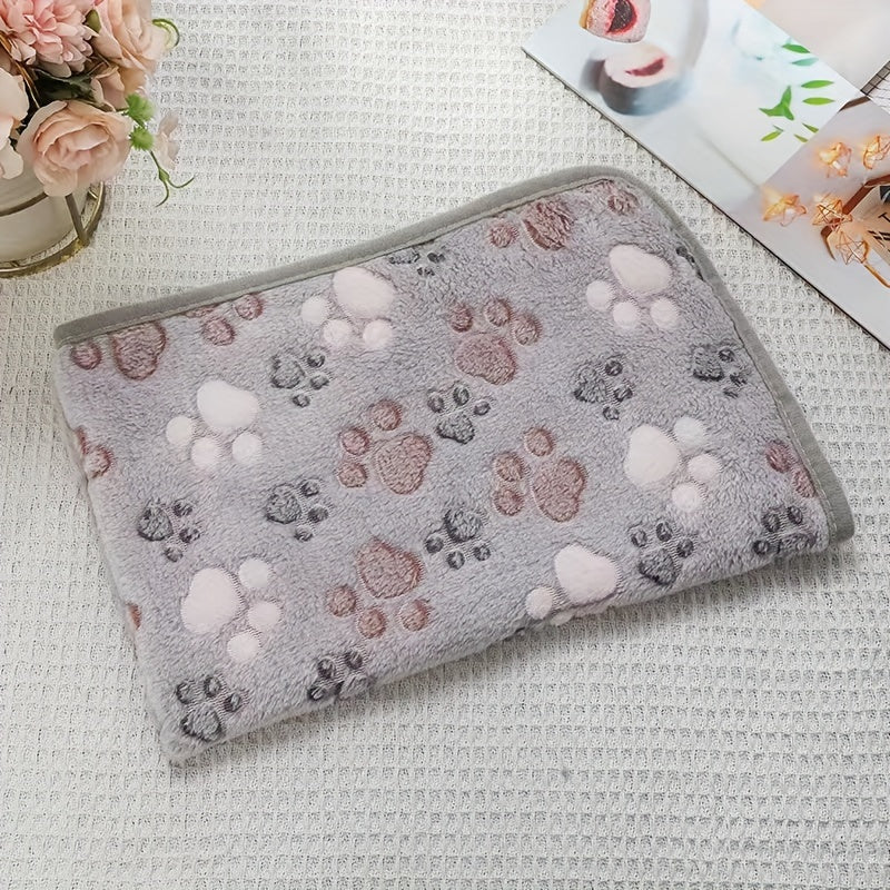 Paw print patterned pet fleece blanket, machine washable and stain resistant, suitable for all dog sizes.