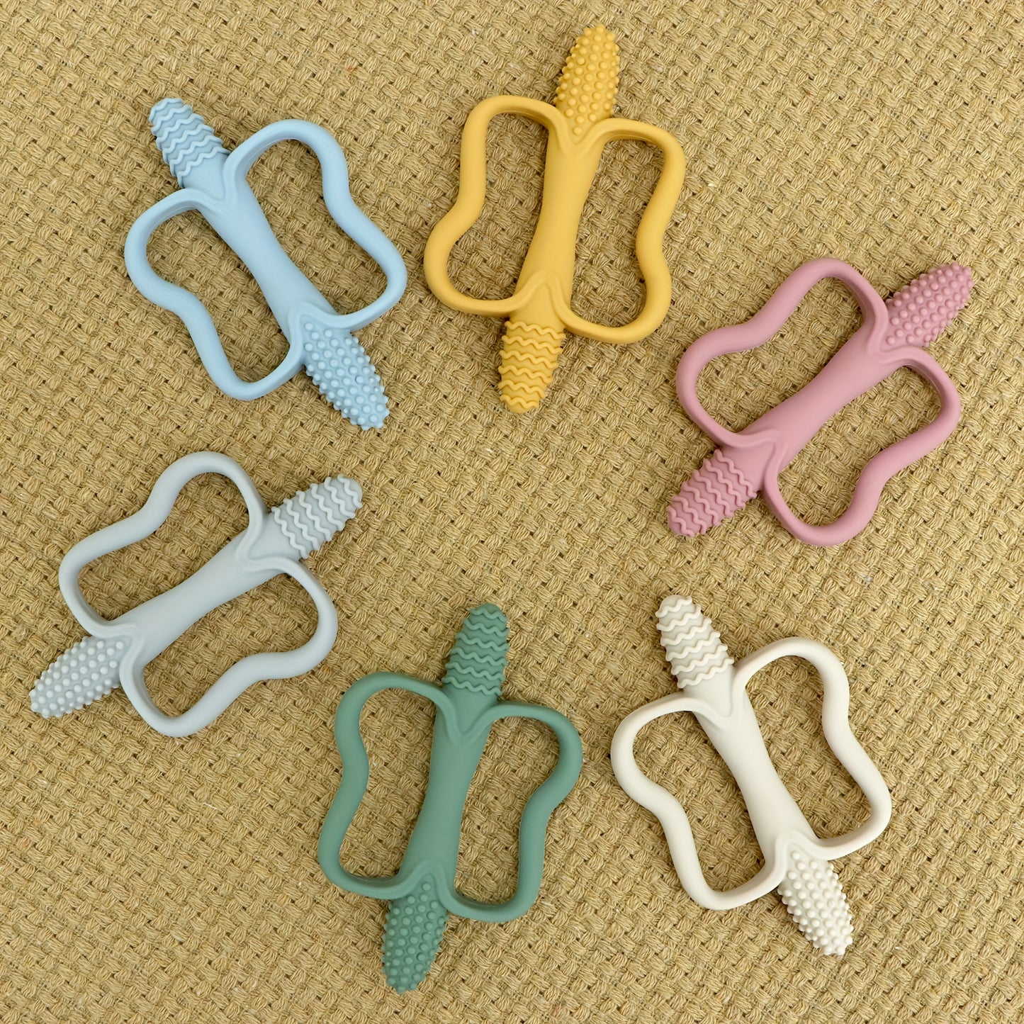 Corn-shaped teething stick with handle, available in 6 colors.