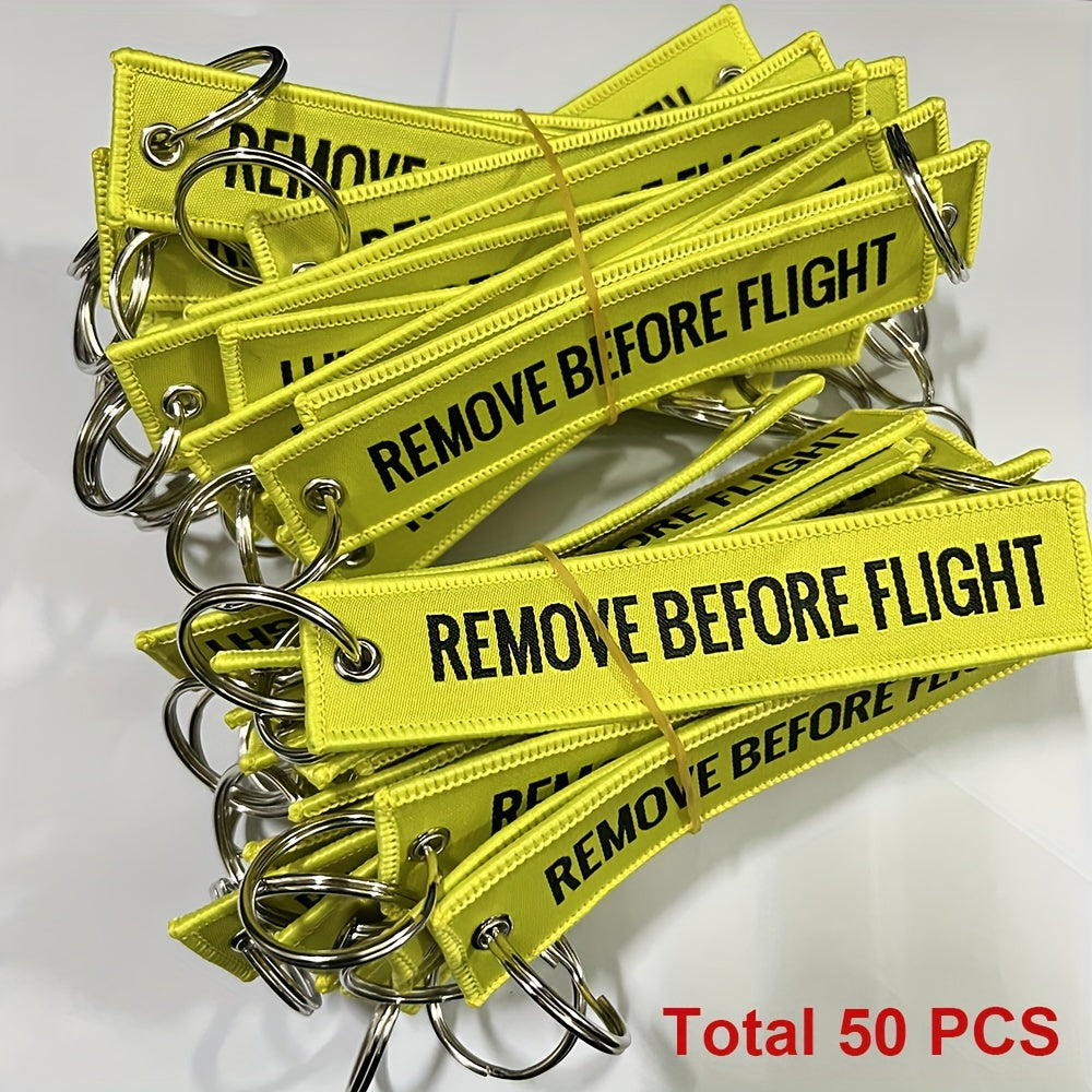 Bundle of 50 'Remove Before Flight' Woven Keychains made from sturdy polyester material - Ideal present for pilots and aviation fans, featuring the iconic phrase "REMOVE BEFORE FLIGHT