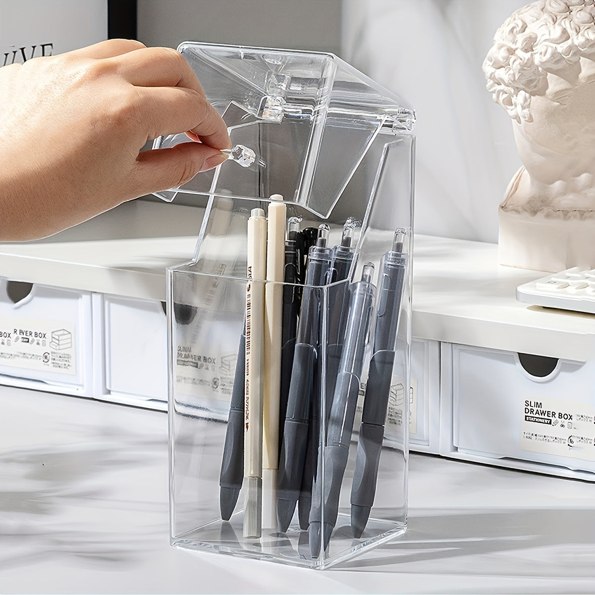 Clear acrylic desk organizer with lid for makeup brushes and pens. Transparent design for easy access and visibility. Made of clear acrylic material.