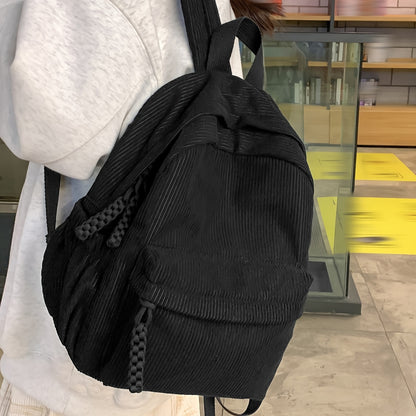 Small corduroy fashion backpack for women in black, with adjustable straps and zipper closure