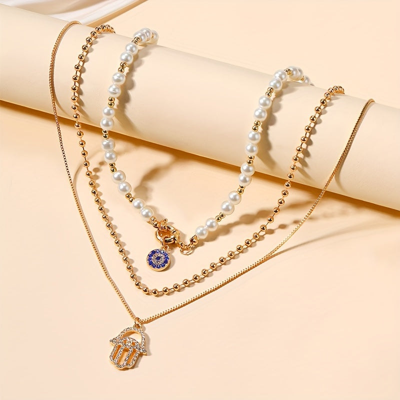 Multi-layered imitation pearl necklace featuring evil eye and Hamsa hand pendants, designed in classic punk style. Made with synthetic stones, alloy material, and no plating. Suitable for both men and women for everyday and vacation wear. Can be worn in