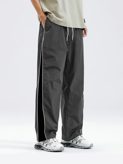 Men's black lightweight joggers with drawstring waist, perfect for spring and fall. Made of polyester fabric with a loose fit and glossy finish.