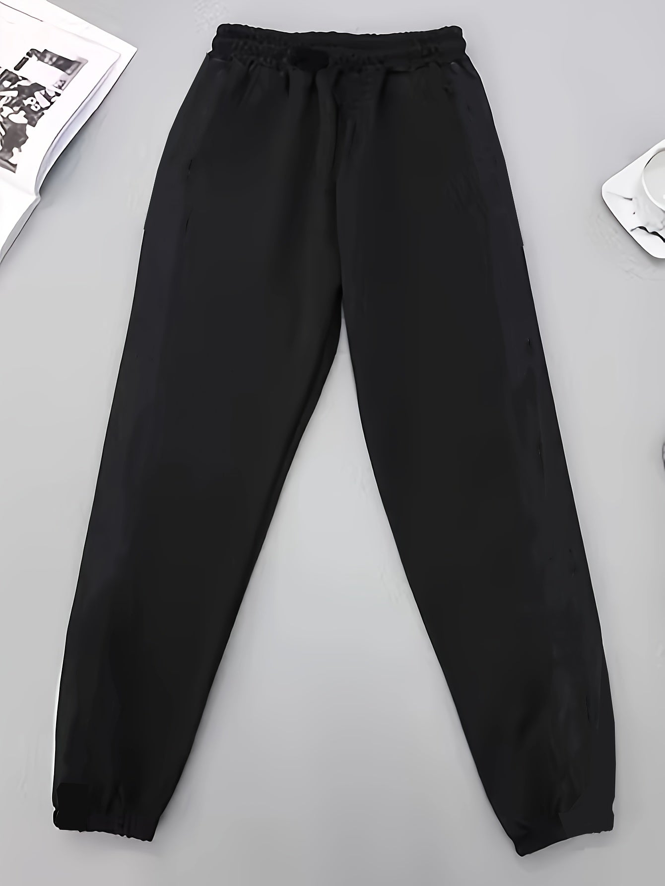 Men's lightweight stretch joggers with contrasting side panels and elastic waistband, perfect for spring/fall sports and leisure activities. Made from a polyester and elastane blend.