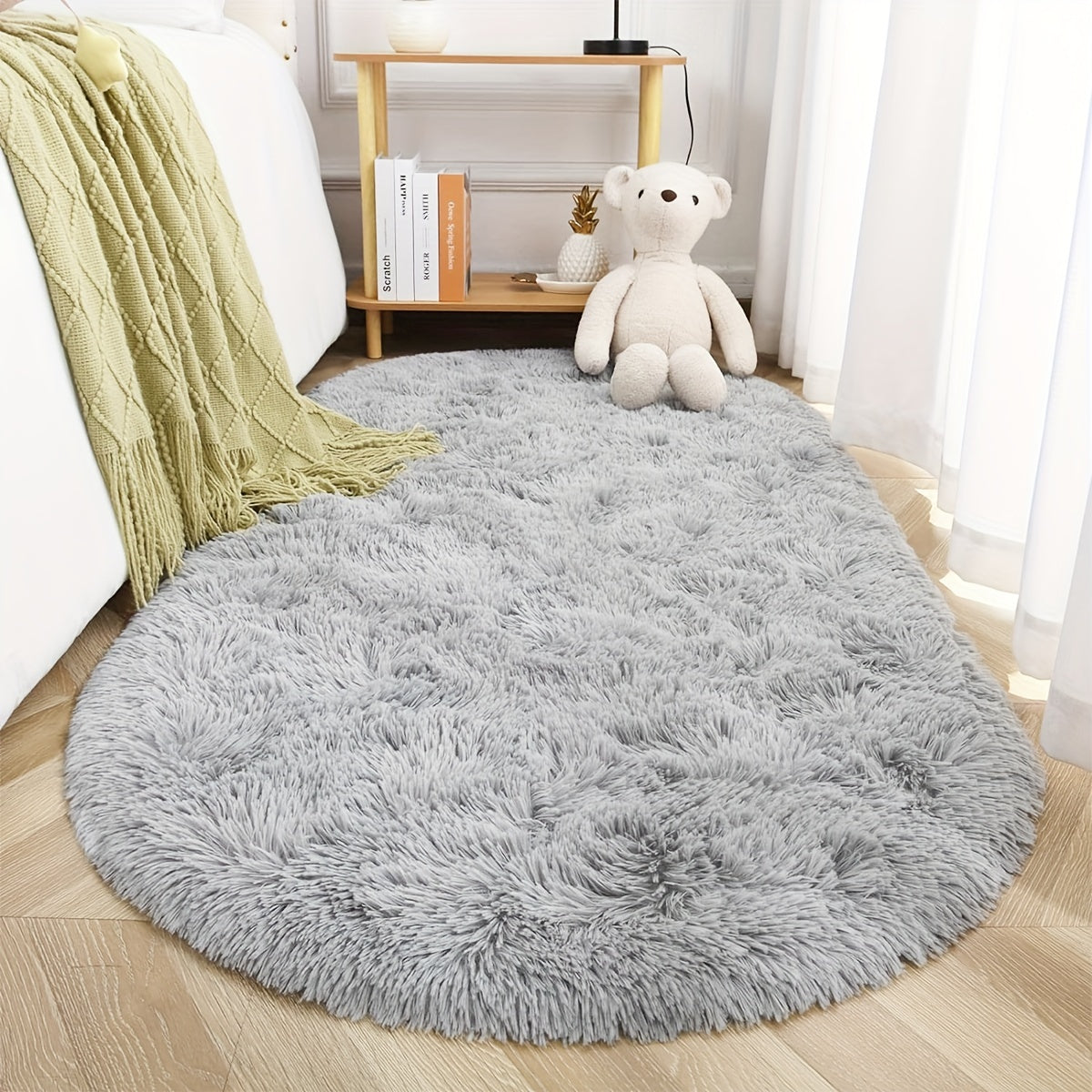 Soft and fluffy oval shaggy area rug, perfect for bedroom or living room. Made with skin-friendly thickened sponge and tufted polyester material. Durable and easy to maintain. Adds decorative touch to indoor spaces such as sofa, bedside, playroom, or