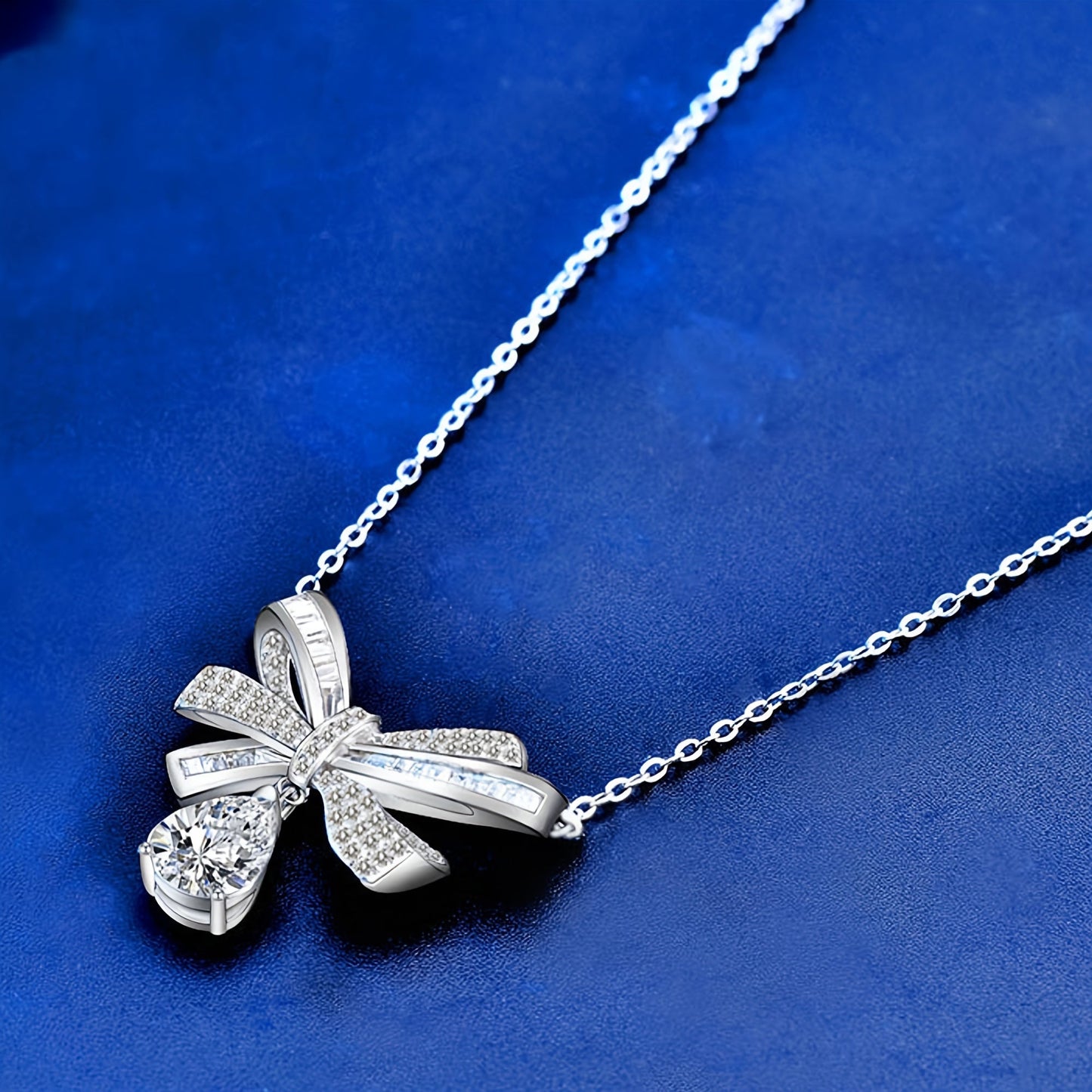 This elegant pendant necklace features 2.0 carats of moissanite in a teardrop tassel bow design, crafted in pure S925 silver. It is a high-end fashion accessory perfect for everyday wear, with its simple and elegant design suitable for parties and as a