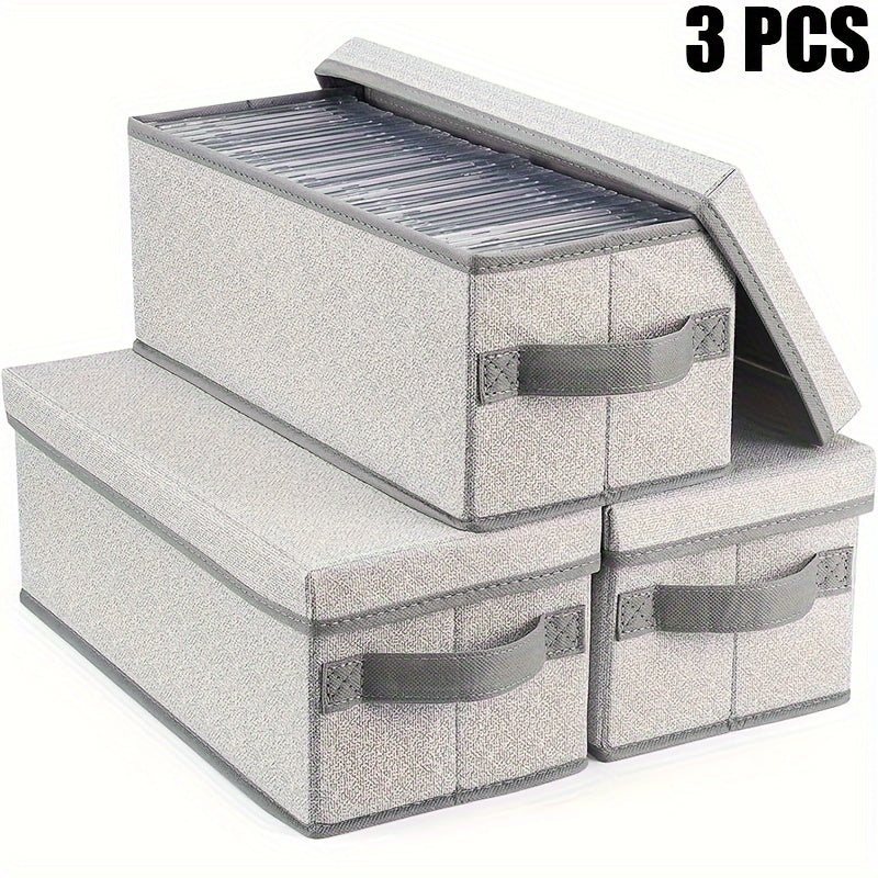 Set of three fabric CD storage boxes with lids and handles, featuring a brushed finish. Can be used as a multipurpose recessed shelf DVD organizer. This electricity-free media case is perfect for use at home, in the office, or in the car. Can hold up to