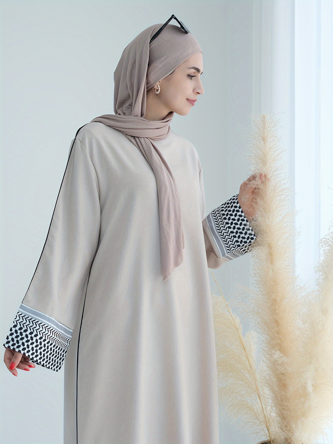 Stylish embroidered zippered abaya dress with long sleeves for Middle Eastern Muslim fashion. Made from polyester knit fabric, part of the spring/fall collection. Features a regular fit and