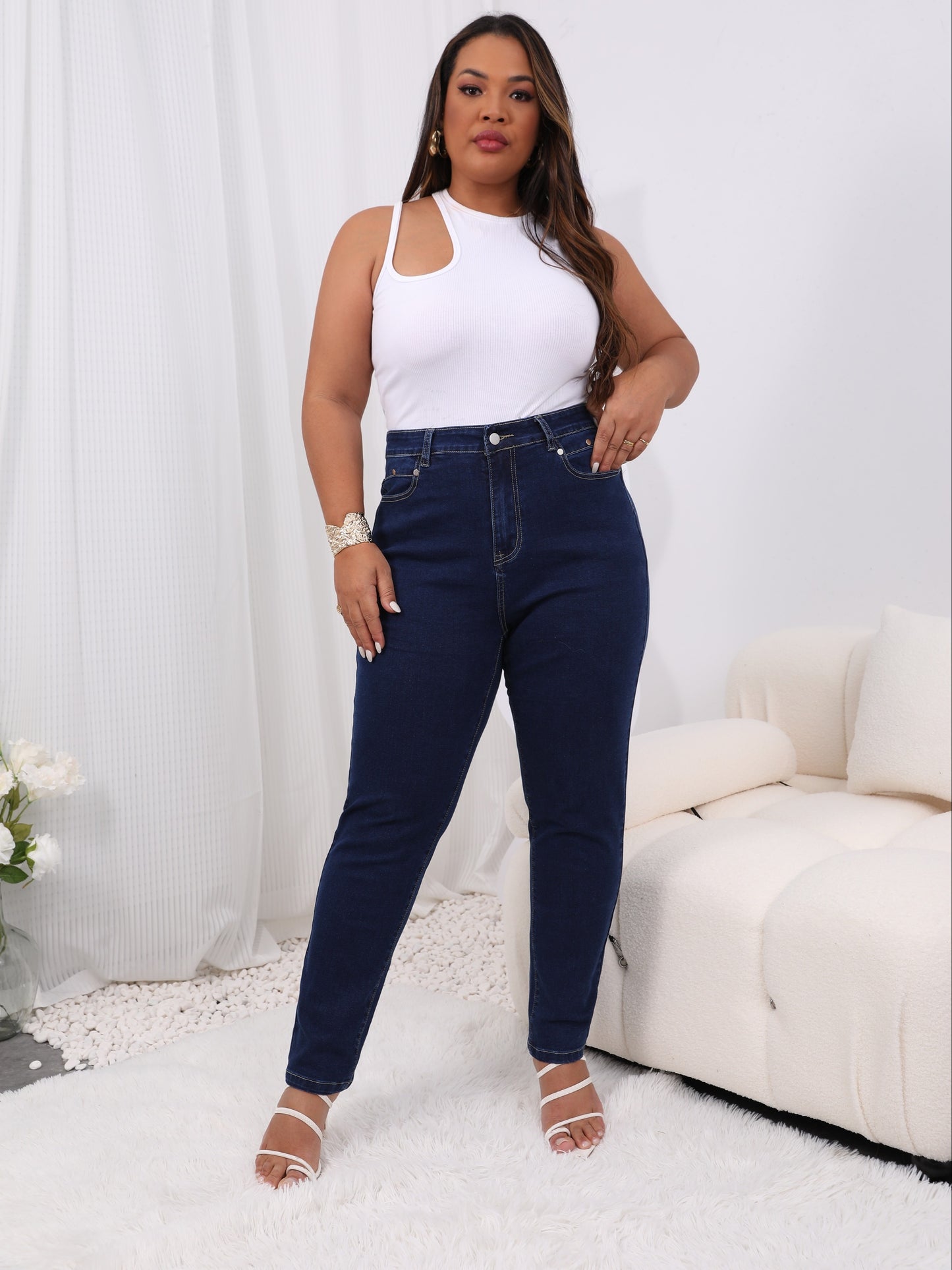 Women's plus size high-rise jeans with solid color and button fly, offering a comfortable stretch fit.