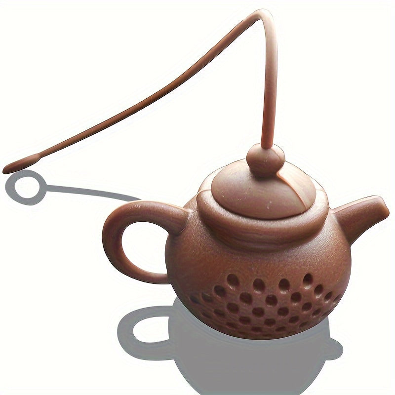 Reusable teapot-shaped tea infuser made of silicone for loose leaf tea, ideal for kitchen and dining use, small in size suitable for making tea.