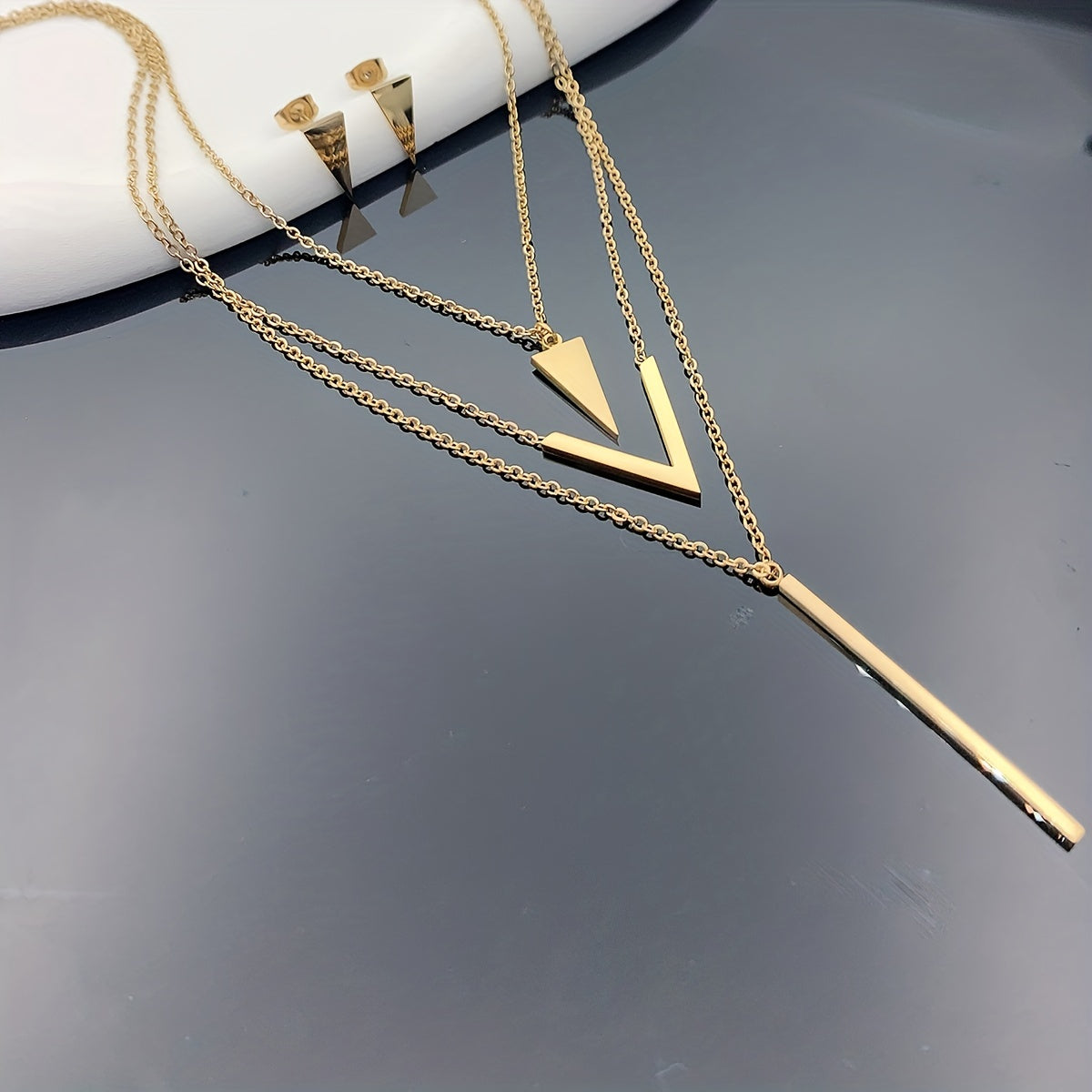 Three pieces of Stainless Steel Long Strip V-shaped Geometric Pendant with a Multi-layer Necklace and Triangle Earrings. Perfect as a Birthday or Holiday Gift, Clothing Decoration, or Party Accessories.