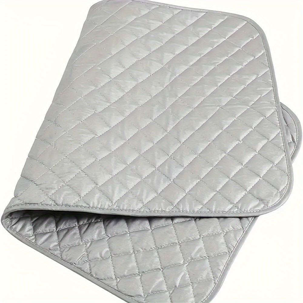 A portable ironing pad with a silver-plated exterior and a thick cotton interior. This heat-resistant, non-electric countertop pad is perfect for travel, hotel stays, or dorm rooms. It can also be used as a multifunctional laundry mat for dryers, washing