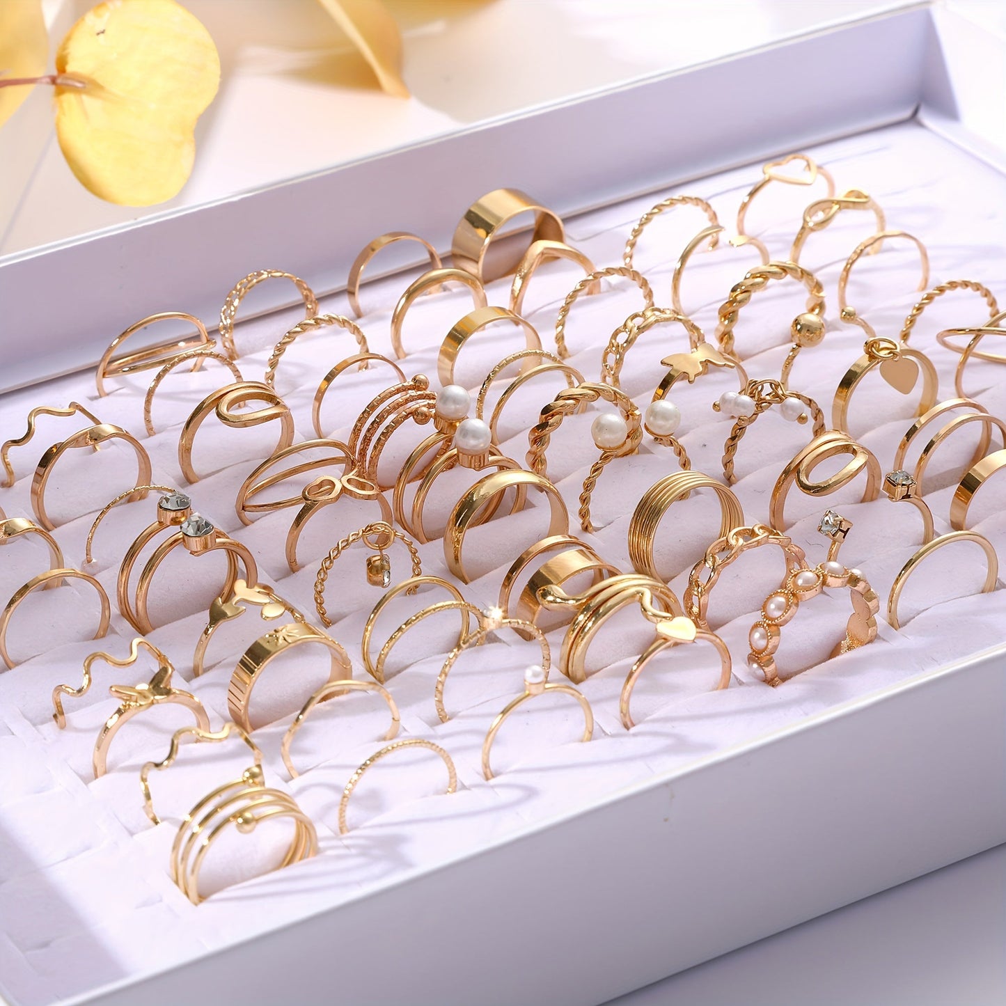 This stylish stackable ring set features 68 pieces adorned with faux pearls and cubic zirconia, showcasing elegant heart and butterfly designs. The rings are in a beautiful golden tone, perfect for everyday wear or special occasions. Perfect for adding a