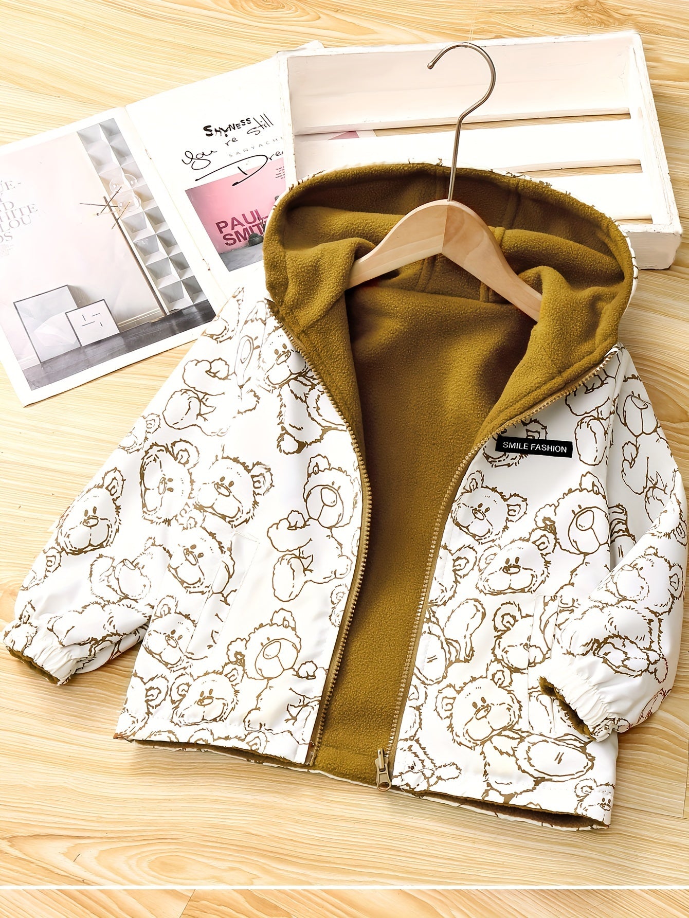 Kids' reversible hooded jacket featuring a cute bear pattern, fleece-lined for warmth in fall/winter. Made of polyester with pockets.