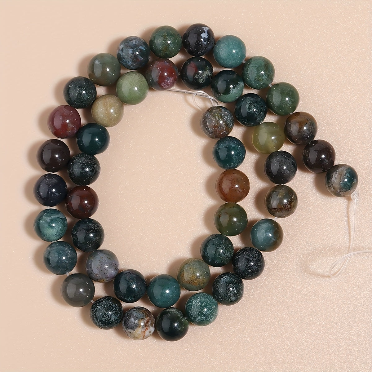 Indian Agate Round Loose Spacer Beads available in natural stone, perfect for DIY bracelet making. Each strand measures 15 inches in length with bead sizes of 4, 6, 8, 10, and 12mm. Ideal for creating unique jewelry accessories.