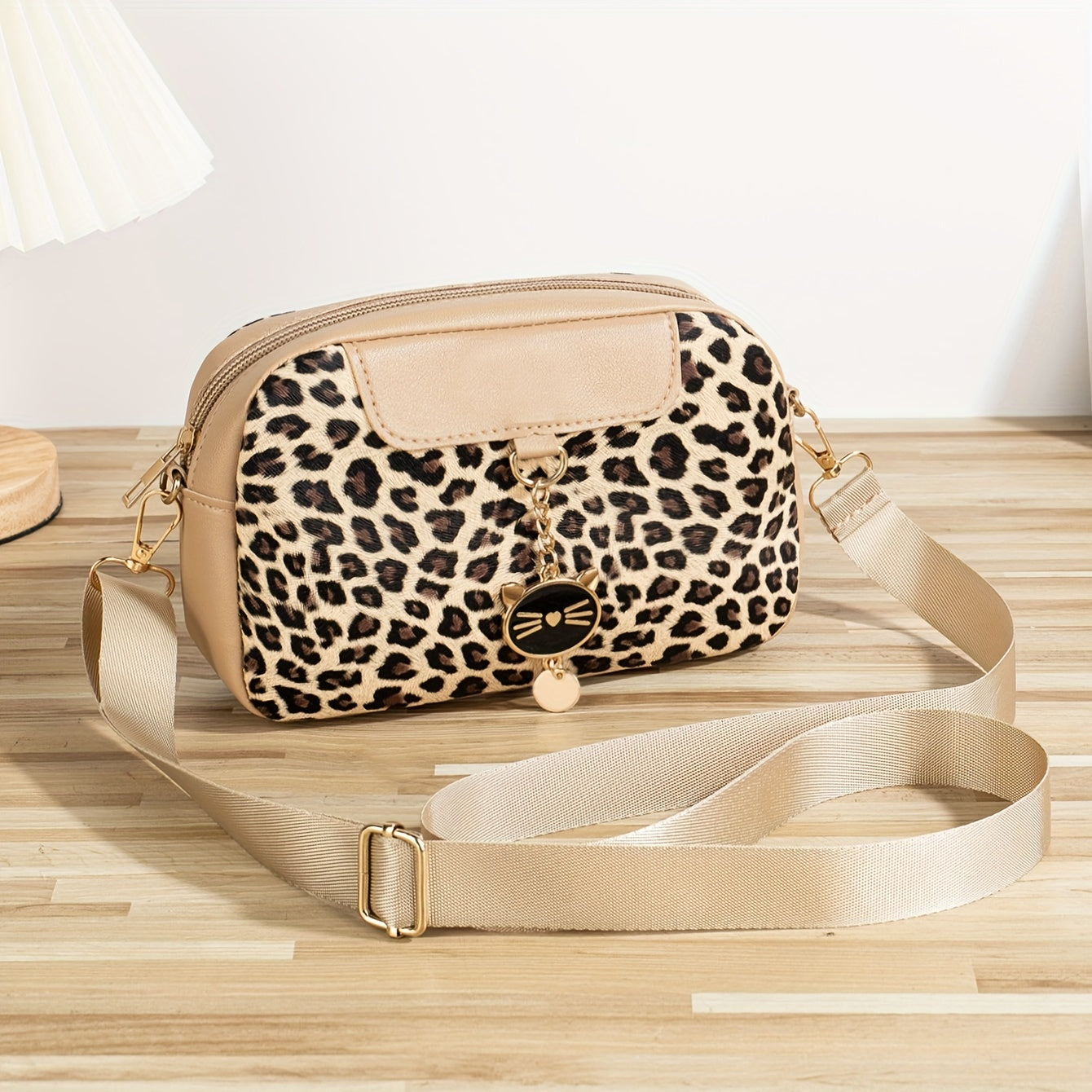 Chic leopard print crossbody bag with adjustable strap, cat charm, zip closure, and polyester lining - ideal for work, outings, and daily commutes.