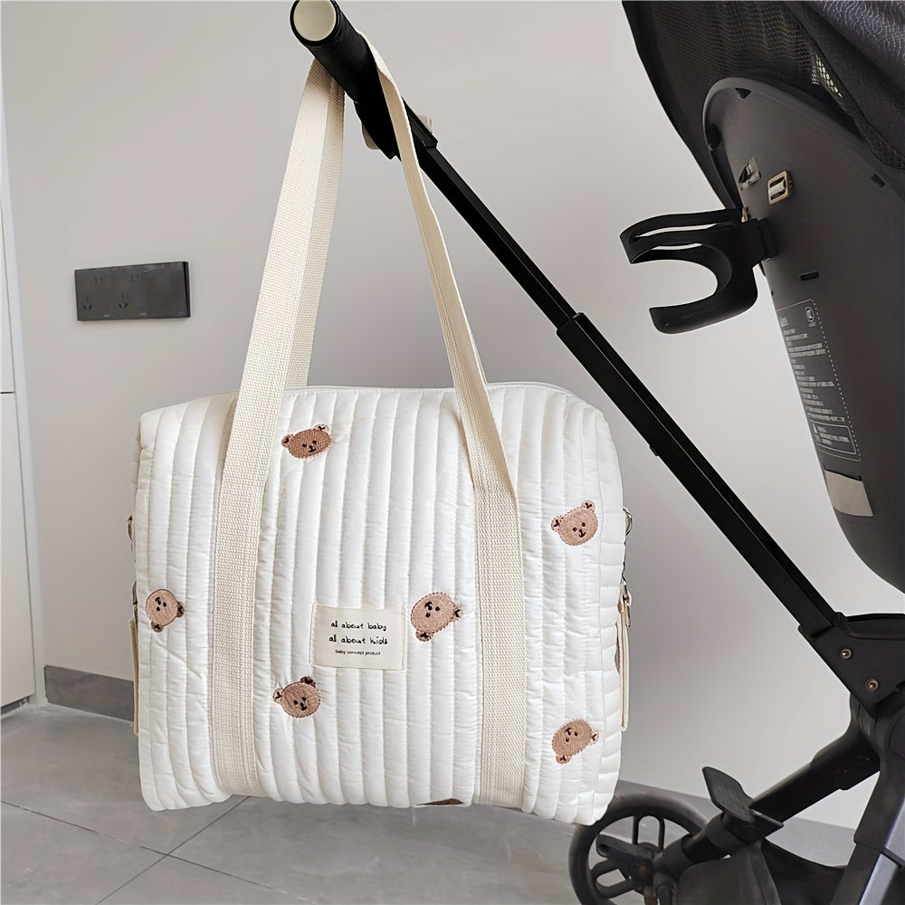 Cotton embroidered and quilted mommy handbag with trolley and hanging feature. Includes diaper bag, bottle finishing bag, and multifunctional mother bag. Zipper style closure. Measures 36x30x12CM.