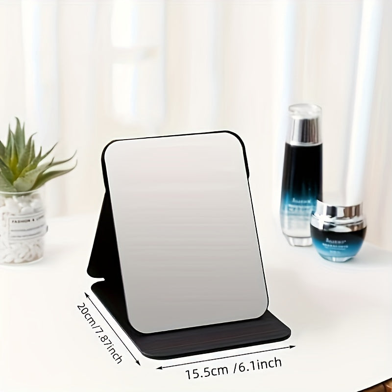 Stylish black foldable makeup mirror, great for desk, bedroom, and bathroom decor. Ideal for travel and makes a unique gift for weddings, parties, and birthdays. Glass surface with polished finish.