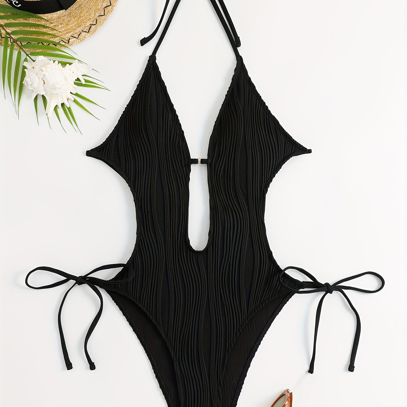 Sexy, high stretch backless halter one-piece swimsuit for women with tie detail; machine washable.