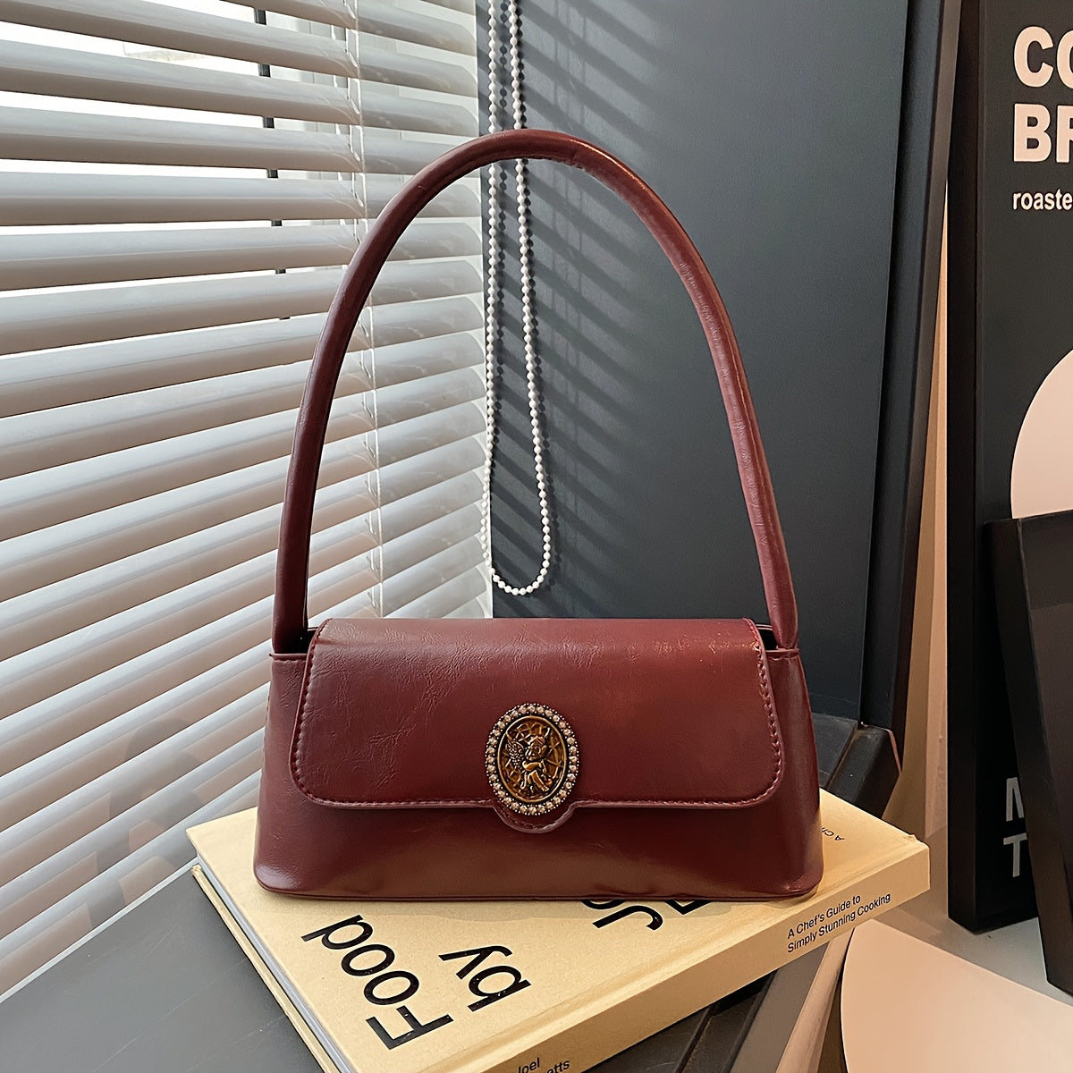 French vintage-style shoulder bag for women in elegant brown, with metal emblem, magnetic closure, and polyester lining. Versatile and stylish for daily use.