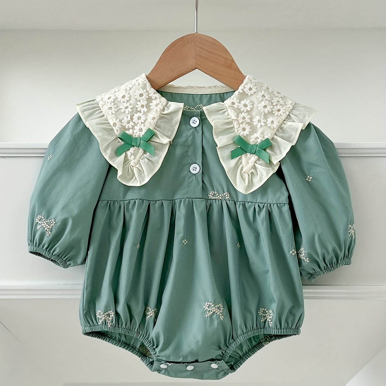 Stylish floral embroidered long-sleeve romper for baby girls, made of cotton with bow detail, ideal for spring/fall and outdoor wear.