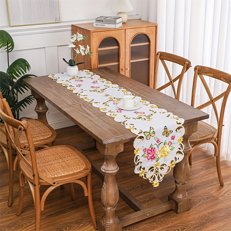 Elegant polyester table runner with hand-cut embroidered flowers and butterflies, perfect for home decor, restaurants, picnics, and parties. White base with vibrant floral patterns.