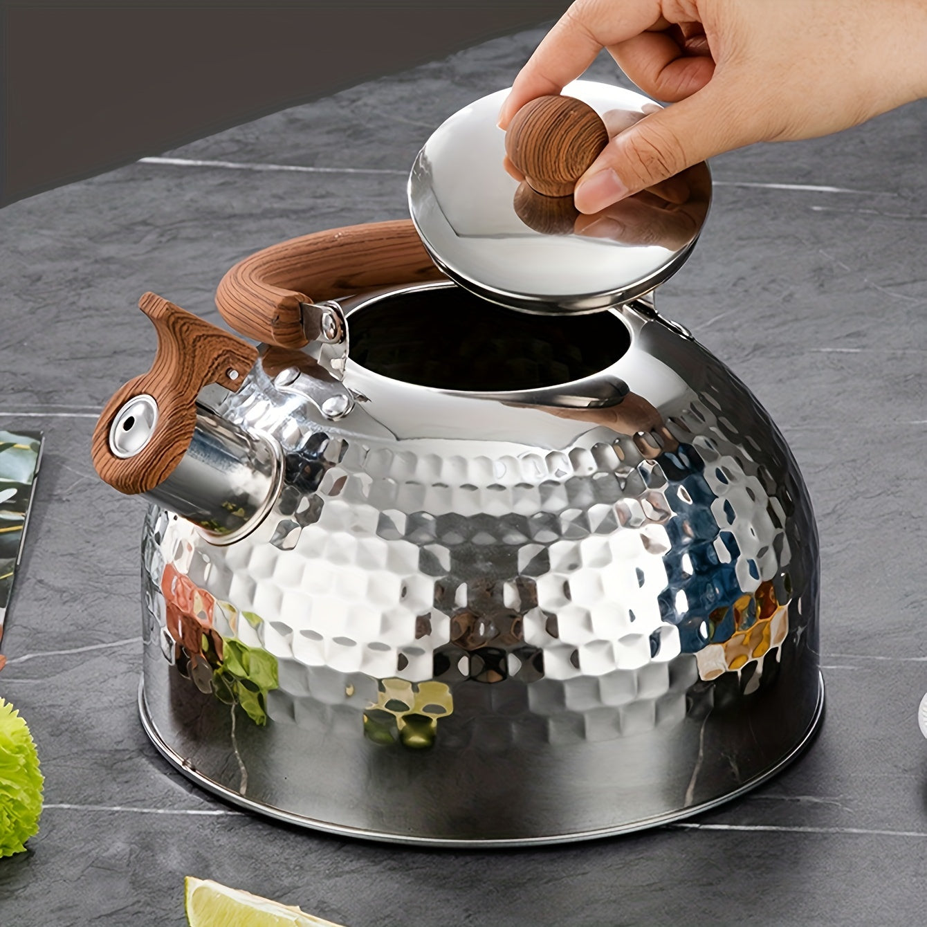 An outdoor-friendly stainless steel kettle with a hammered texture and a whistling spout, ideal for boiling water in the backyard to make tea or coffee.