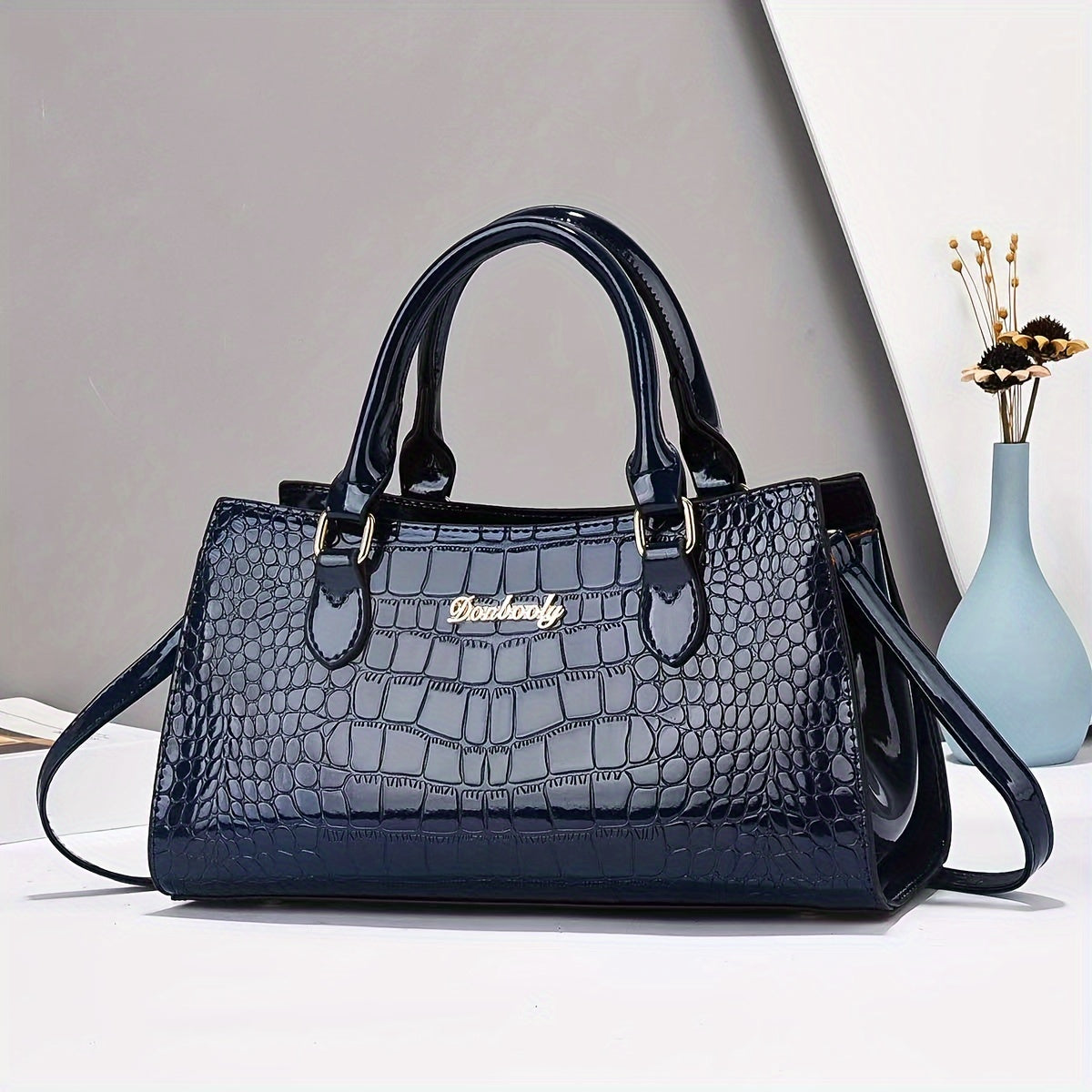 Fashionable black crocodile-embossed women's handbag with adjustable strap, zip closure, and wrist strap. Lightweight and versatile for everyday use, can be worn as a crossbody or shoulder