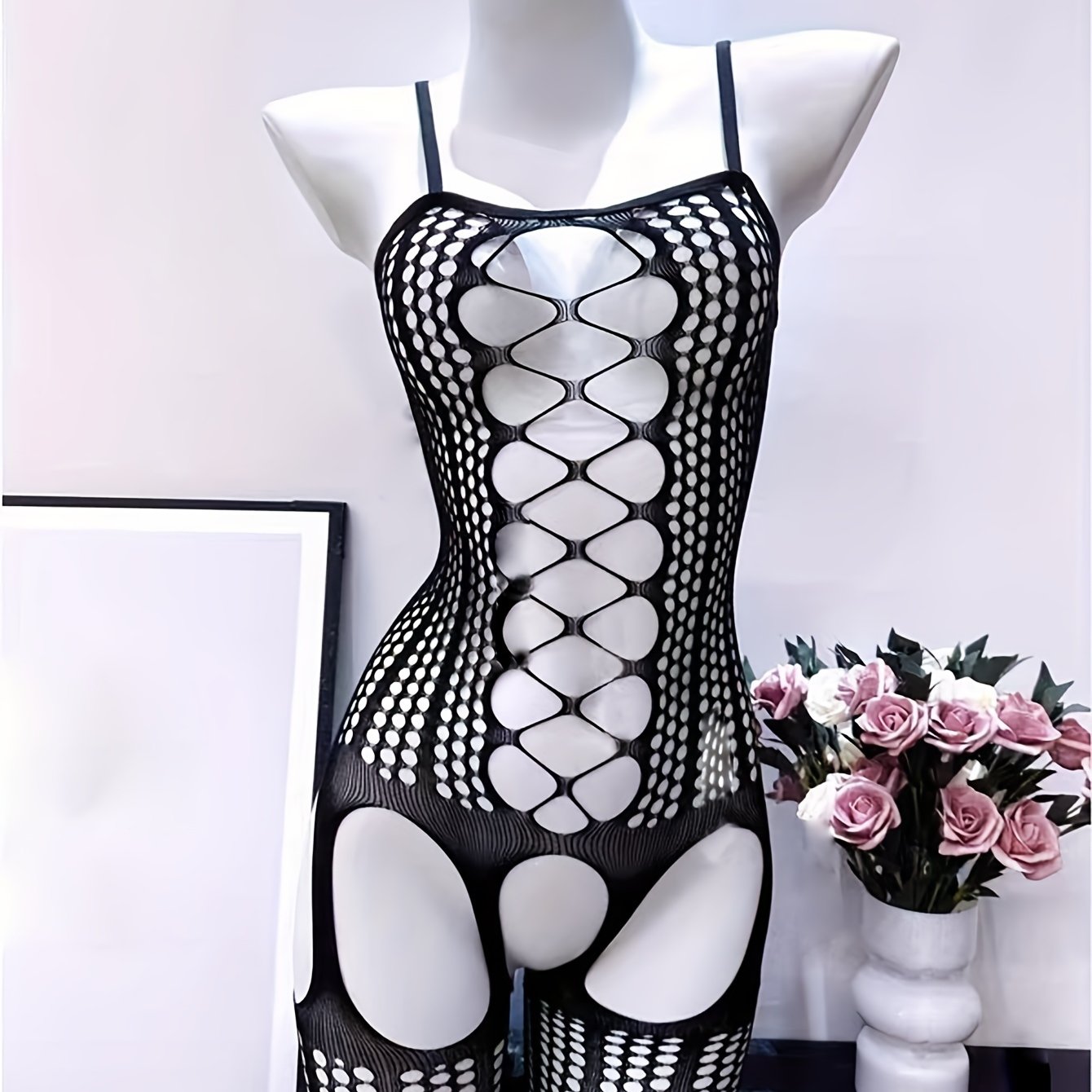 Chic black fishnet bodysuit with hollow out design, see-through cover-up, high stretch nylon/elastane blend. Hand washable, ideal for music festivals and beachwear.