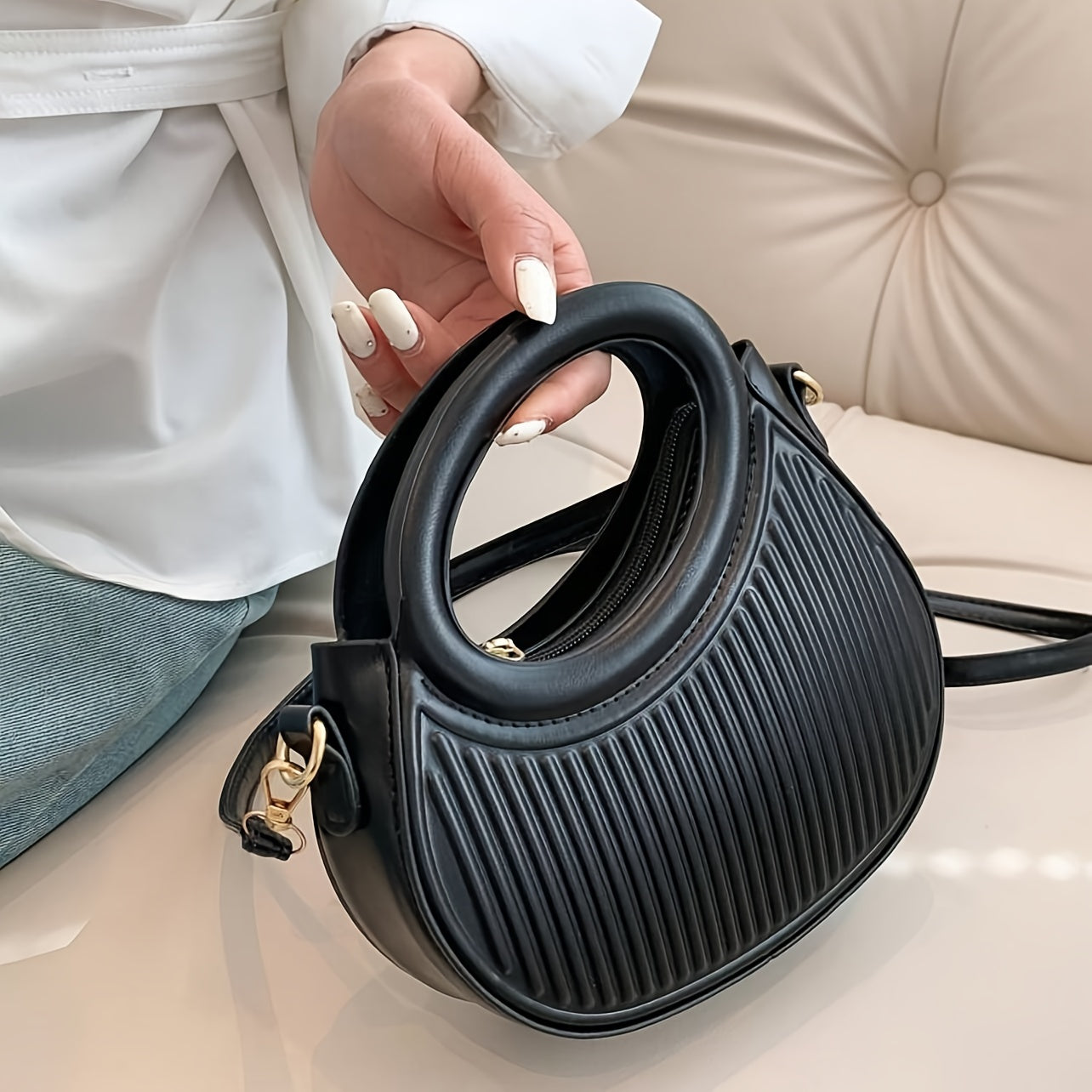 Chic black crossbody bag with embossed stripe pattern and golden-tone hardware, versatile for everyday use with a luxury look.