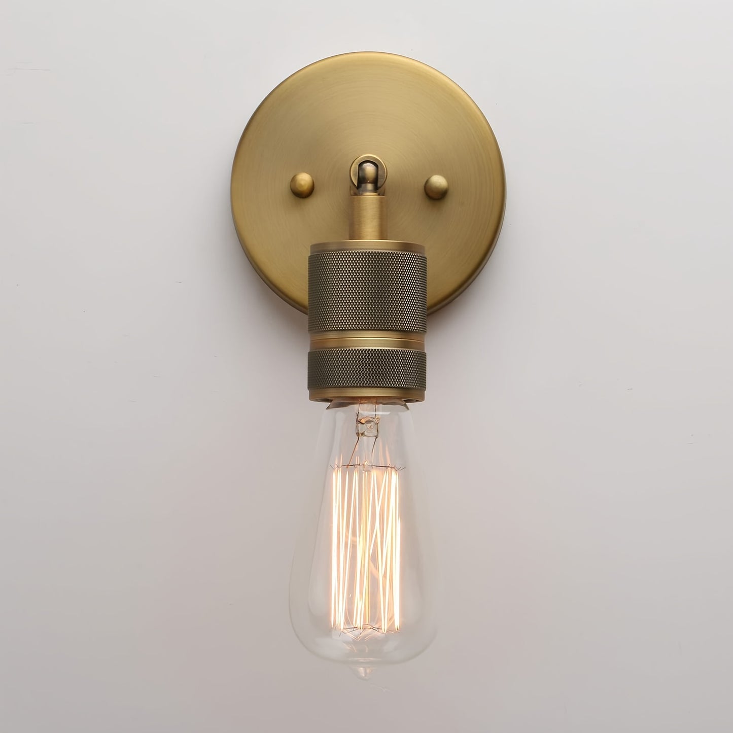 Vintage industrial wall sconce in antique bronze metal finish, suitable for various rooms.