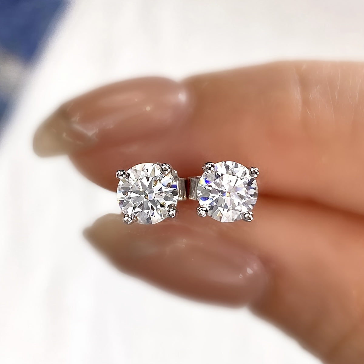 These elegant moissanite earrings come in a pair with a simple four-prong design weighing 1.2 grams for 0.5 carats, 1.7 grams for 1 carat, and 2.5 grams for 2 carats. Perfect for daily wear, these exquisite high-end ladies' jewelry pieces make a stunning