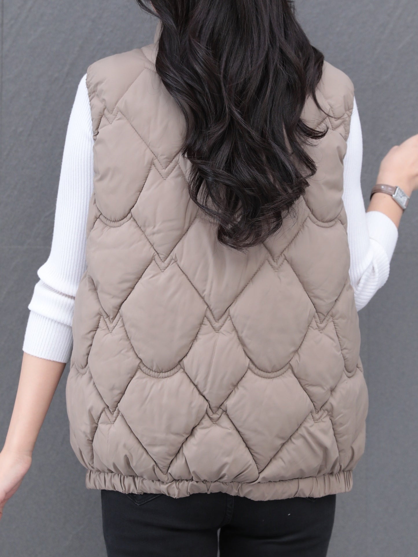 Women's polyester vest with quilted stand collar, zipper closure, pleated hem, and loose fit. Ideal for fall/winter casual wear with a Middle Eastern style.