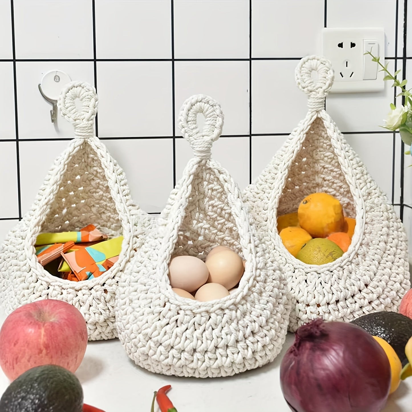 Set of 3 hanging baskets made of cotton rope and sisal crochet, featuring water drops design. This versatile storage solution can be used as a fruit, vegetable, or plant holder, or as a kitchen organizer. Hang them on the wall to save space and add a