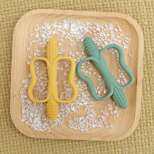 Dental floss designed for children in the shape of corn, featuring a handle for easy use. Made with silicone material and a textured biting surface, this dental floss is suitable for children over 3 months old to safely play and clean their teeth.