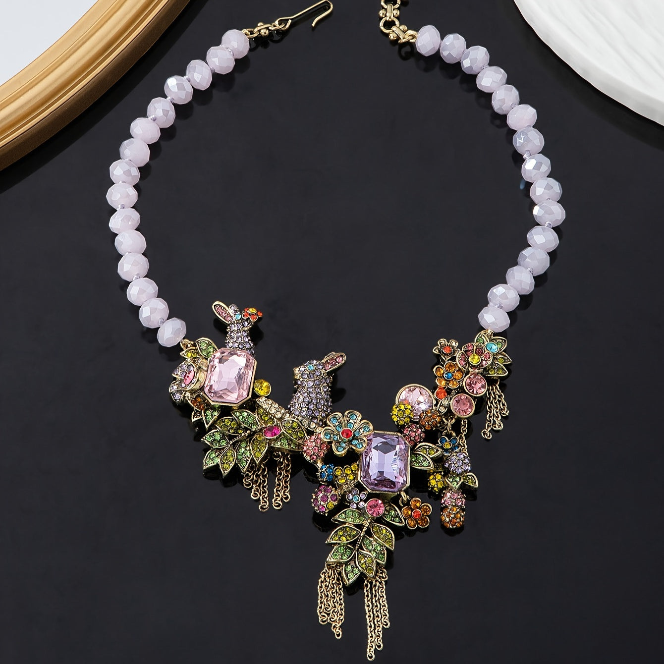 Necklace featuring an ornate vintage-style rabbit pendant with rhinestone tassels, glass crystals, and leaf accents.