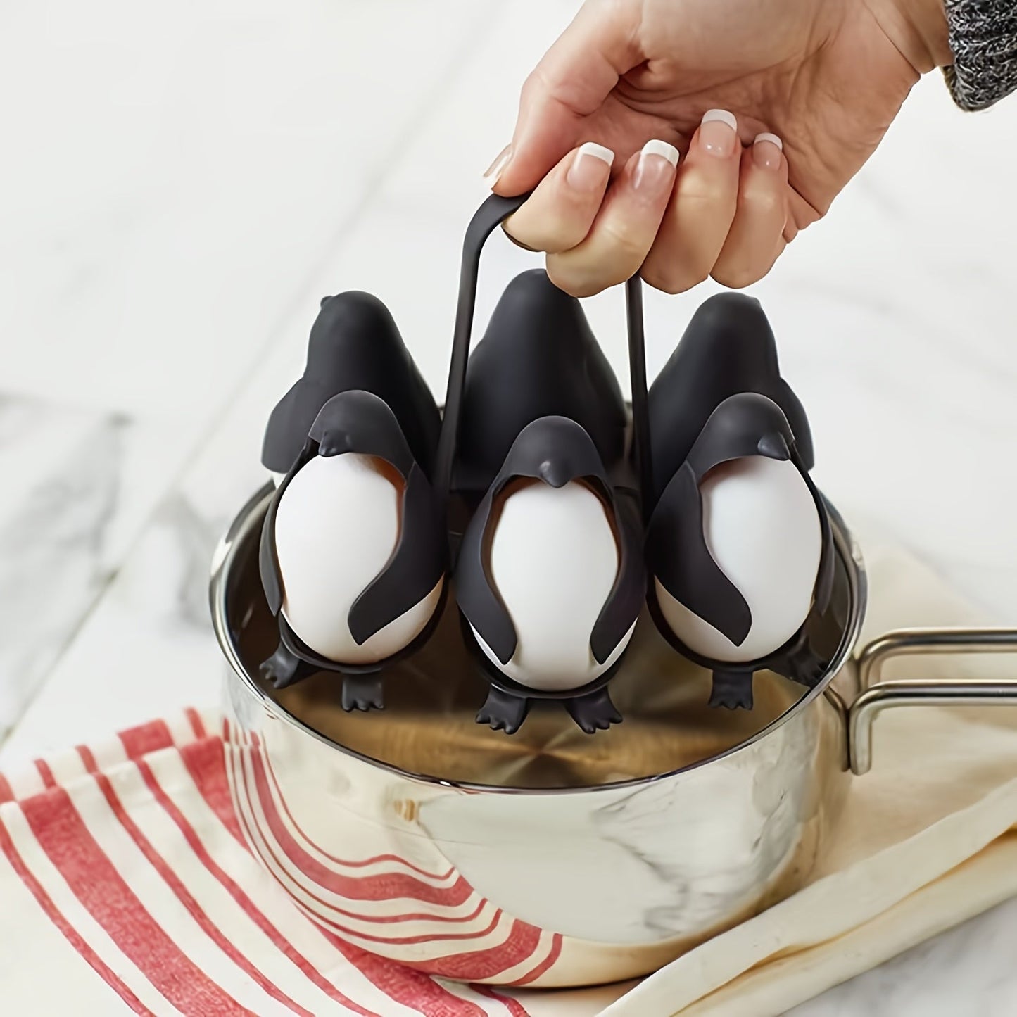 A set of 6 Penguin Egg Cookers made of plastic, perfect for boiling both hard and soft eggs. This food-safe kitchen gadget is a great gift idea for Christmas, Thanksgiving, Mother's Day, and Labor Day.