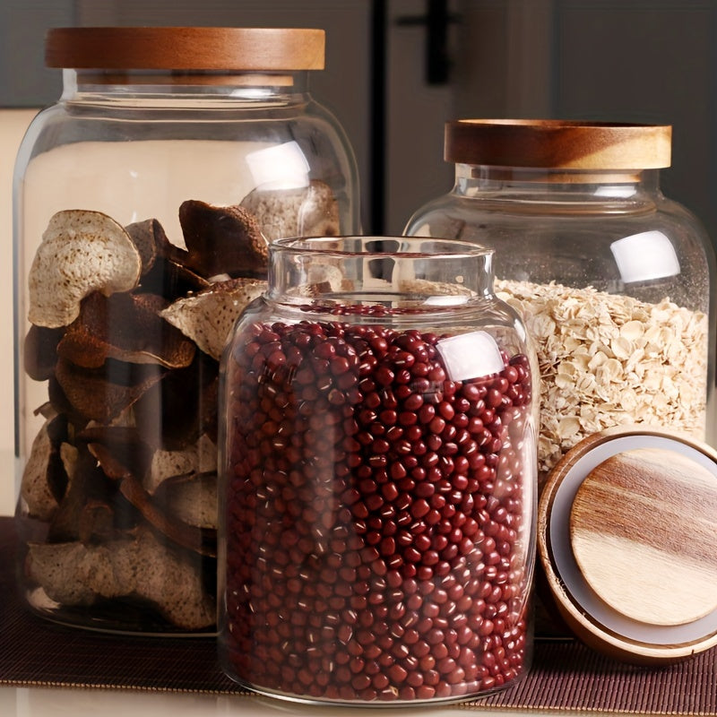 Large glass food storage jars with airtight wooden lids for storing coffee beans, dried food, pasta, tea leaves, overnight oats, grains, and spices. These clear glass canisters are perfect for organizing your kitchen and keeping your ingredients fresh.