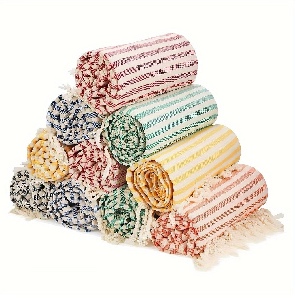 Large Turkish beach towel in vibrant pink, blue, green, and yellow stripes with tassels. Quick-dry, sand-proof, soft, and absorbent. Suitable for pool, bath, and travel.