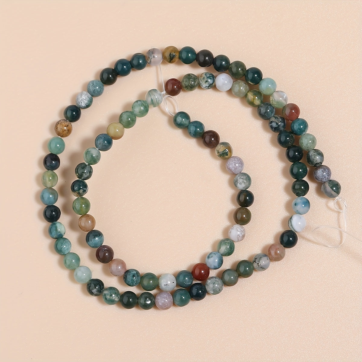 Indian Agate Round Loose Spacer Beads available in natural stone, perfect for DIY bracelet making. Each strand measures 15 inches in length with bead sizes of 4, 6, 8, 10, and 12mm. Ideal for creating unique jewelry accessories.