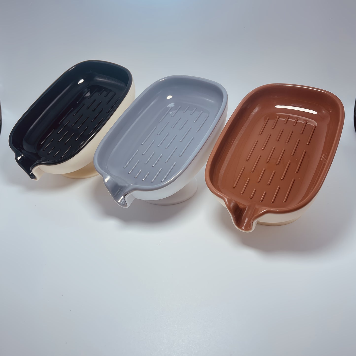 Durable plastic oval soap dish with an elegant, self-draining design for bathroom use.