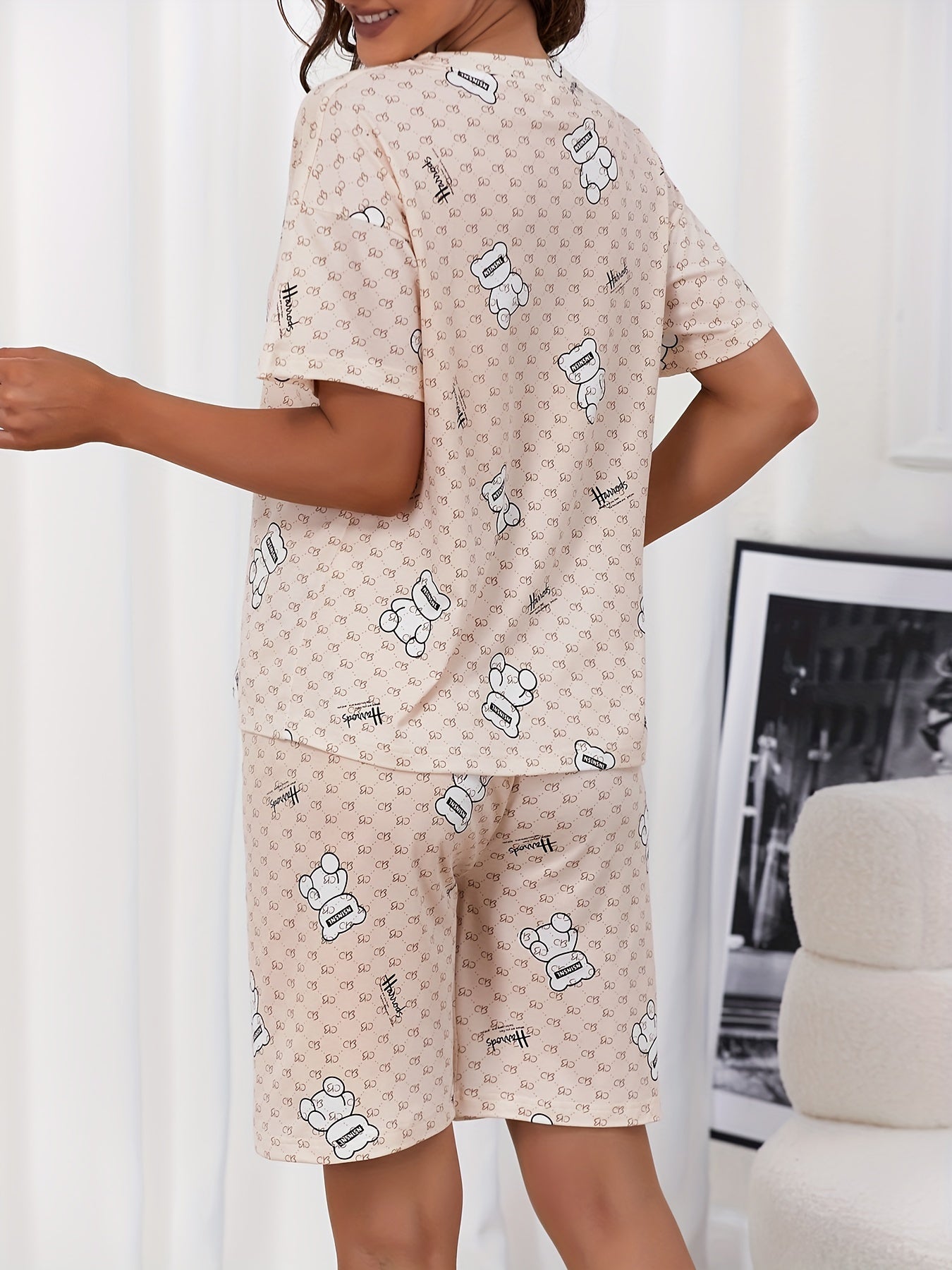 Women's sleepwear set featuring a cute bear and letter print, short sleeve top, and capri pants with a crew neck.