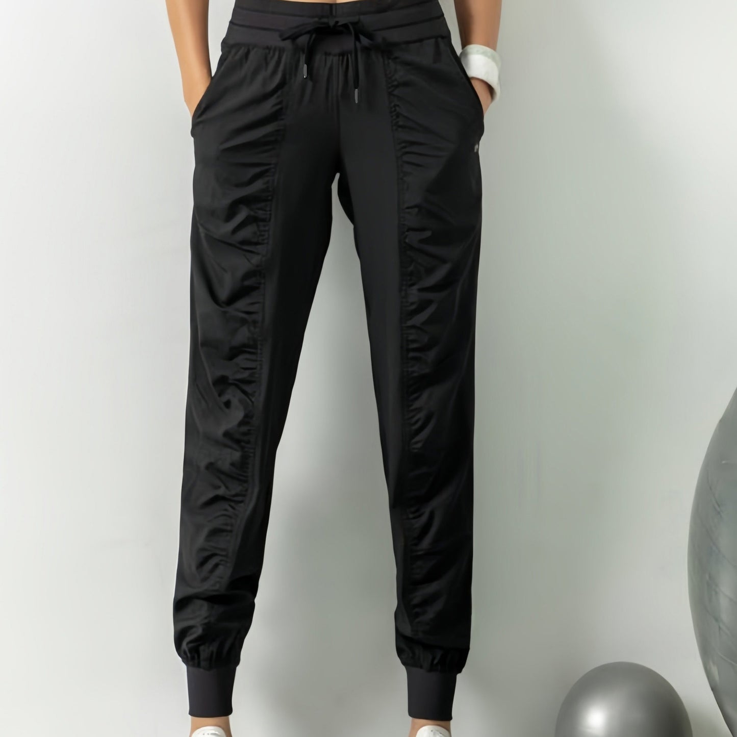 Women's solid color sports pants with drawstring waist, quick drying material, and side pockets for casual comfort.