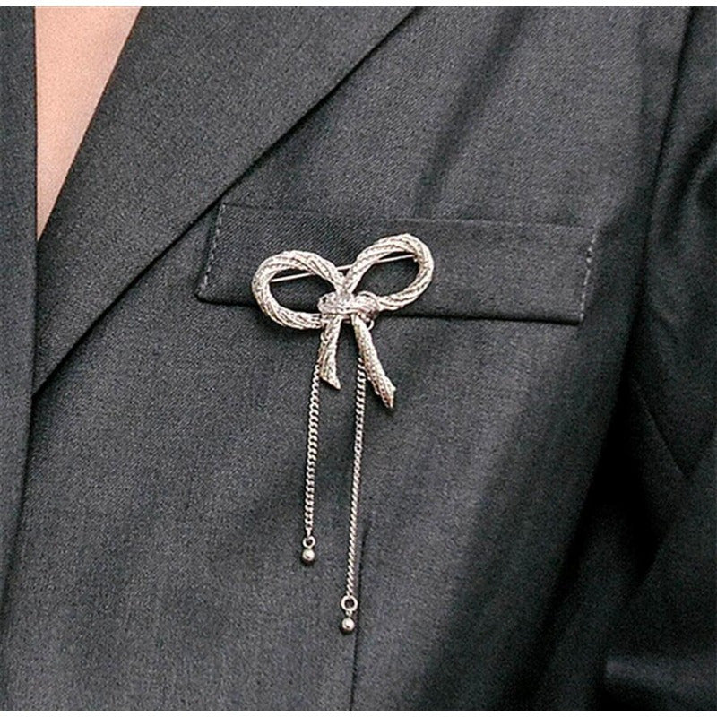 Add a touch of elegance with the SKEDS Bowknot Brooch Pin, featuring a unique design with enamel bow ribbon and tassel chains. This fashionable accessory is perfect for both men and women.