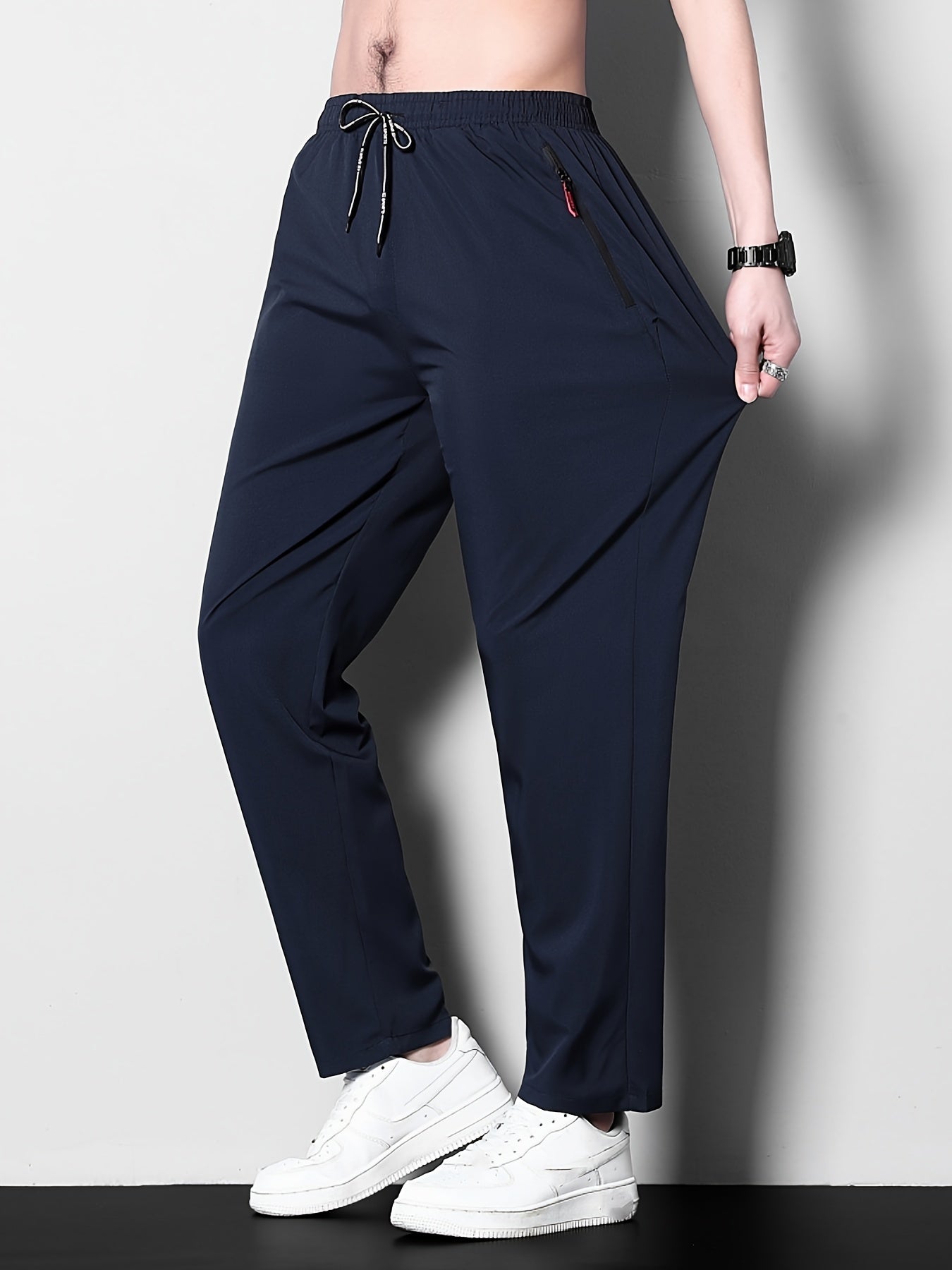 Men's plus size casual sports pants, made of stretchy polyester in a solid color with a regular fit, zipper detail, part of the spring/summer collection.