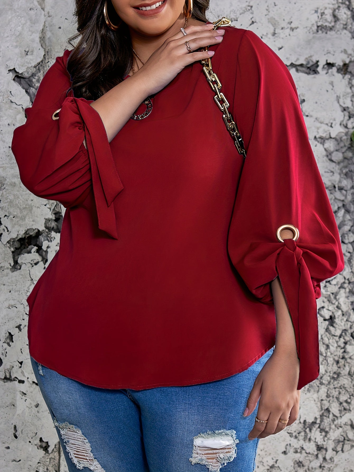 Plus size women's casual top with solid colors, lantern sleeves, round neck, round hem, and knot detail.