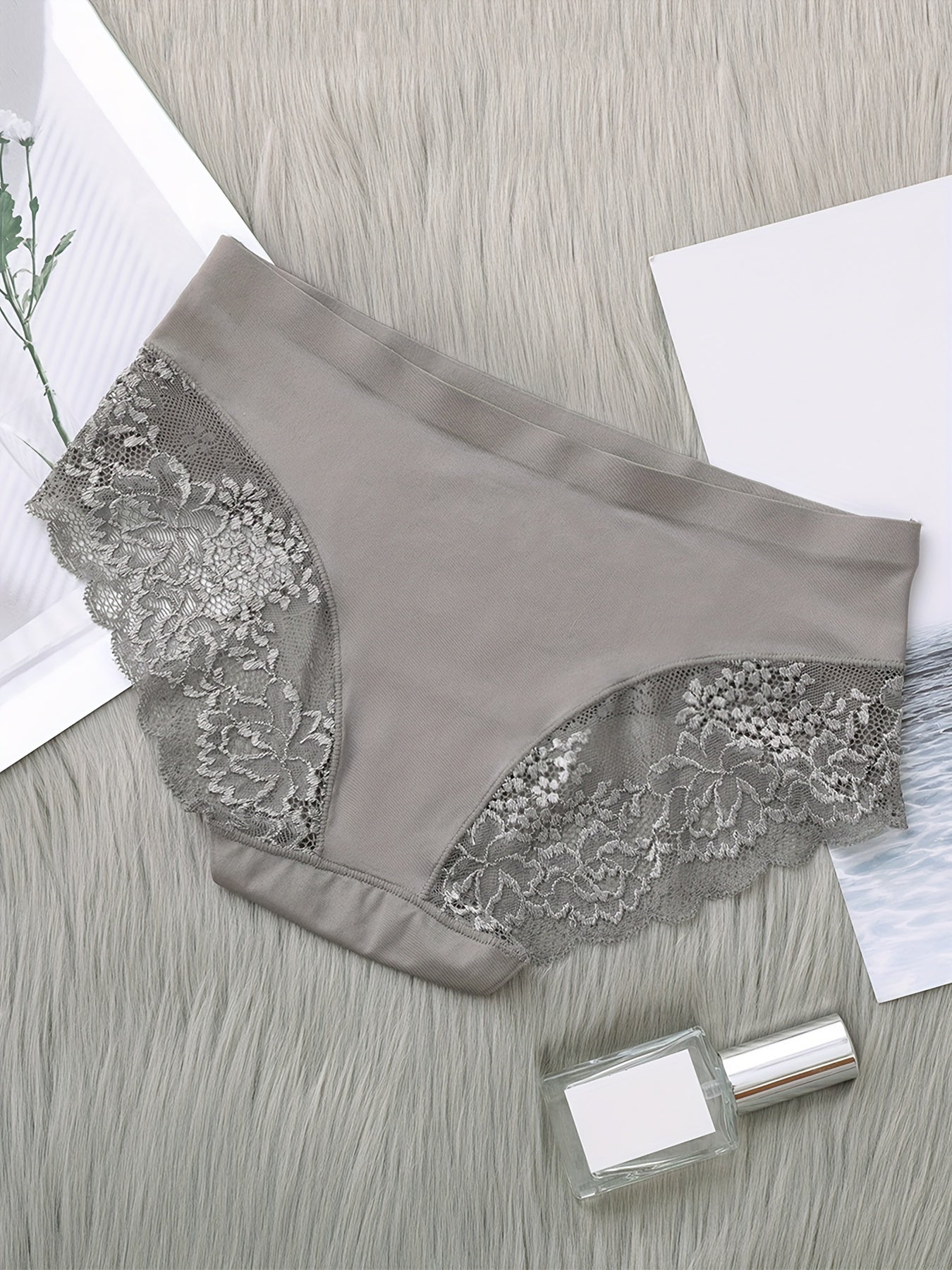 Set of 4 nylon knit fabric mid rise panties for women with solid color and lace details.