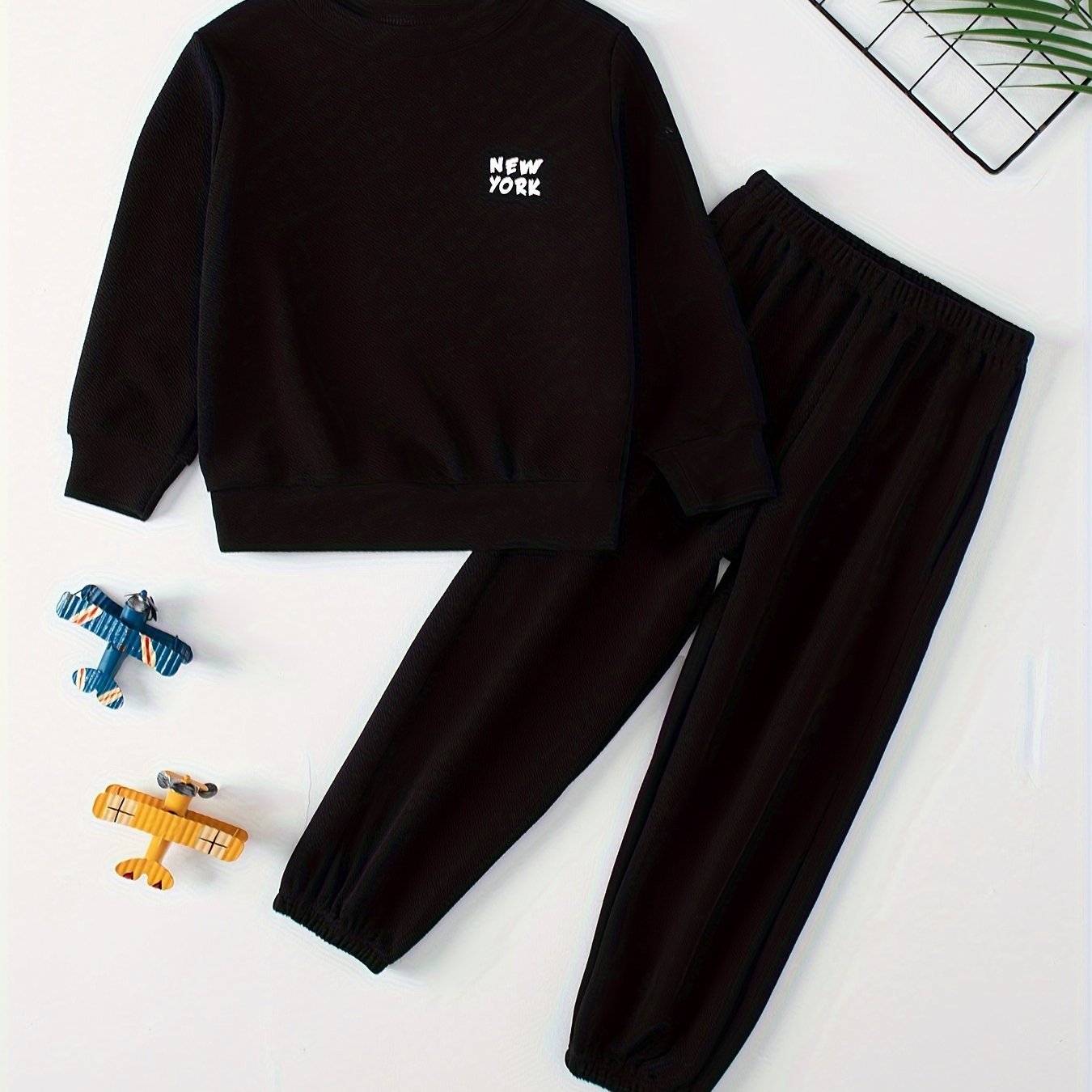 Children's casual sweatshirt and pants set made of polyester and spandex blend. Solid color with round neck, long sleeves, and knit fabric. Regular fit with pocket detail, suitable for