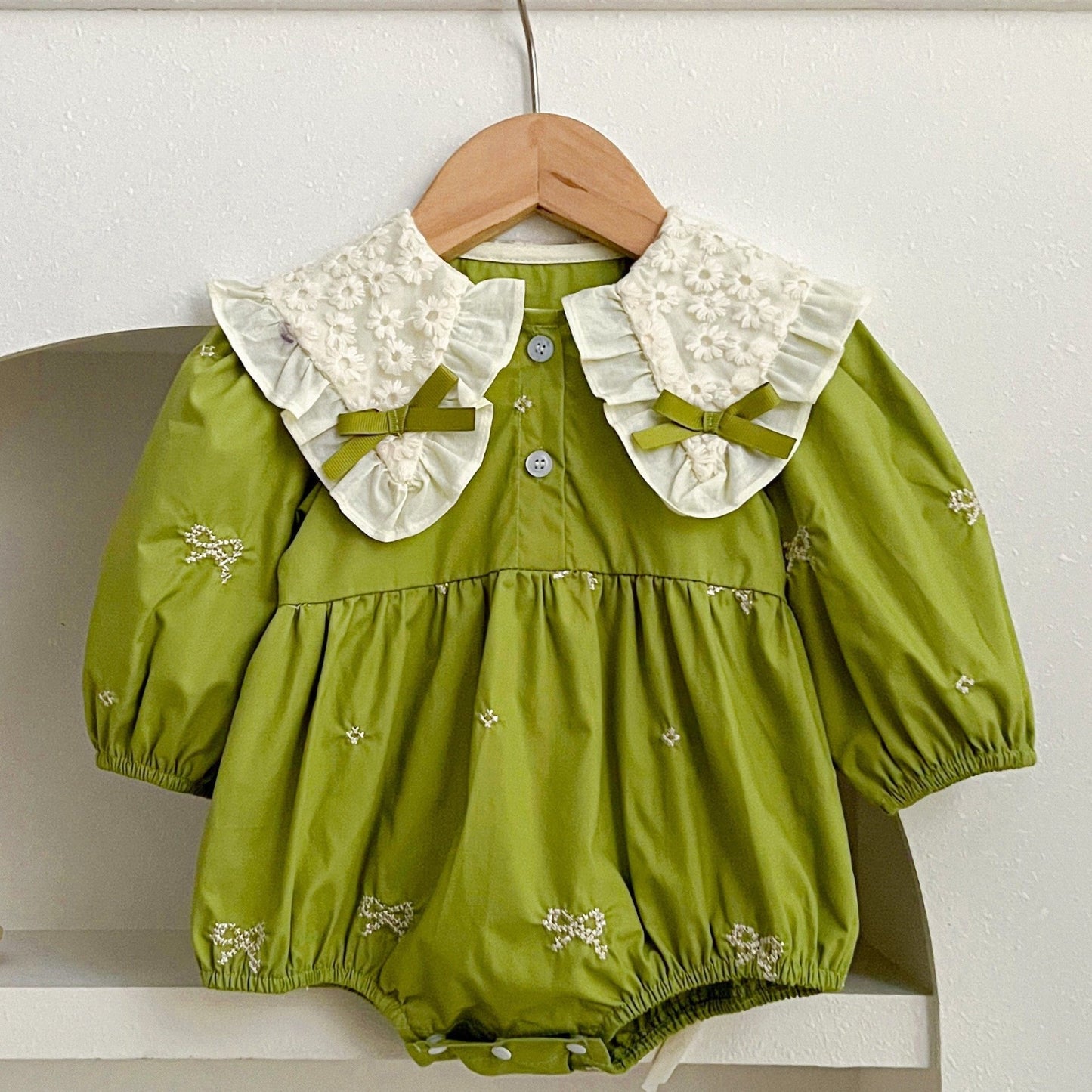 Stylish floral embroidered long-sleeve romper for baby girls, made of cotton with bow detail, ideal for spring/fall and outdoor wear.