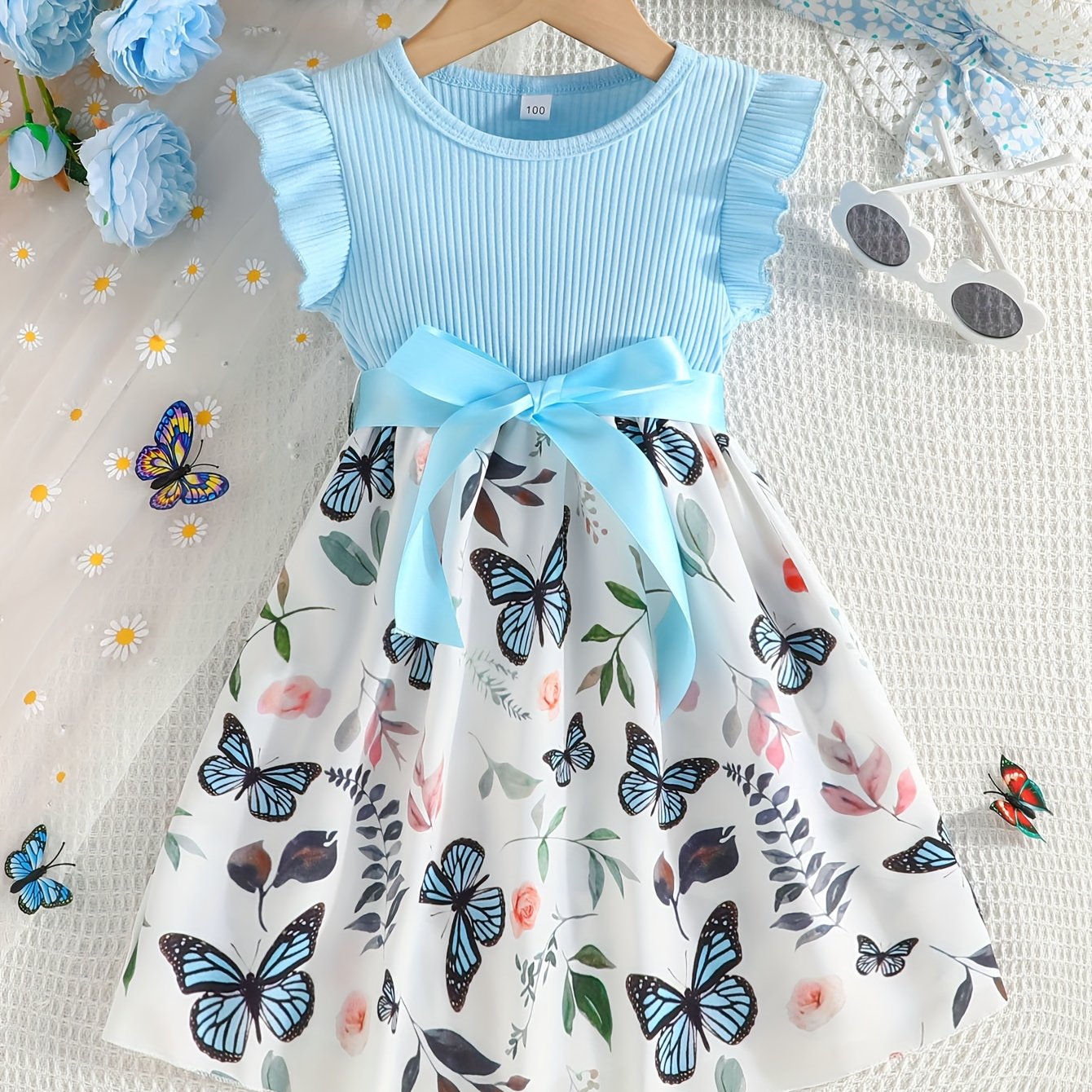 Girls' light blue ribbed cotton dress with butterfly & floral print, flutter sleeves & belt detail. Casual summer wear, machine washable. Dresses for girls.